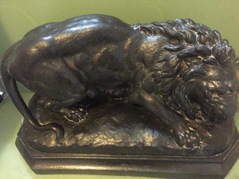 A nineteenth-century bronzed plaster sculpture depicting a prowling lion mounted on an octagonal base. View XXI
