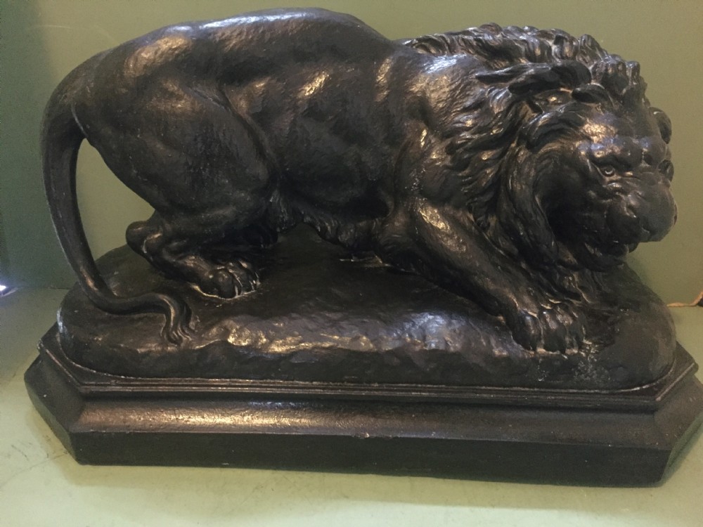 A nineteenth-century bronzed plaster sculpture depicting a prowling lion mounted on an octagonal base. View XX