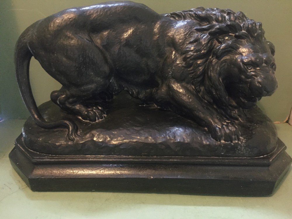 A nineteenth-century bronzed plaster sculpture depicting a prowling lion mounted on an octagonal base. View XXVII