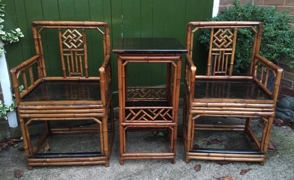 Decorative pair of early C20th Chinese polished bamboo and lacquer armchairs and table in the C18th manner  .