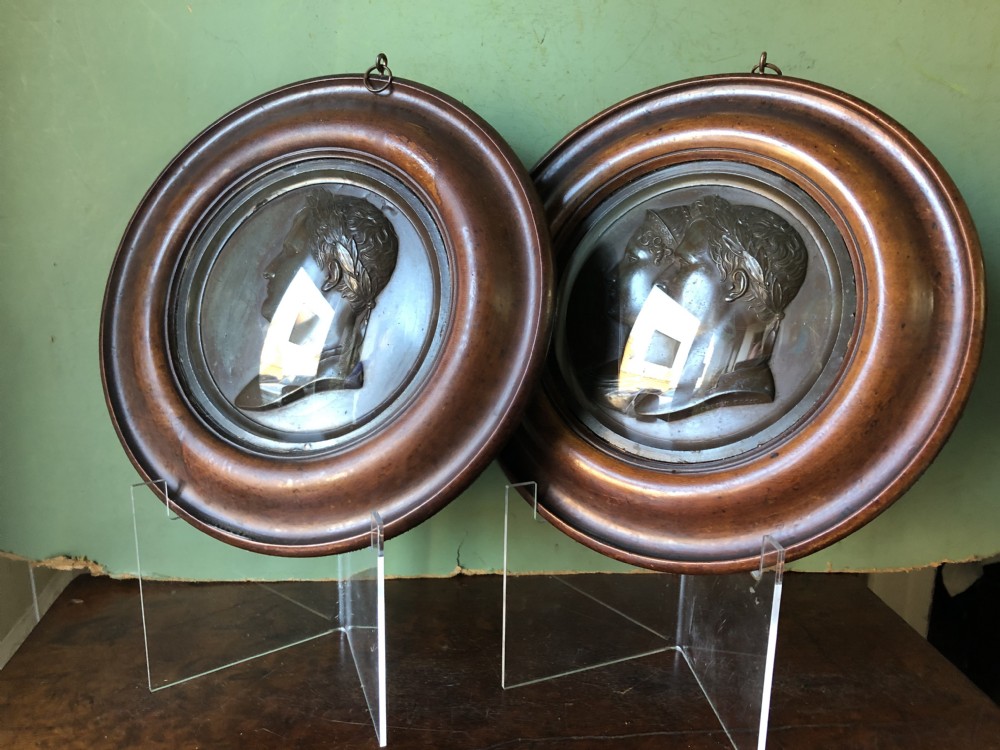 A pair of circular turned mahogany frames enclosing dark bronzed relief profile portraits of Napoleon and Marie-Louise under glass. View IX