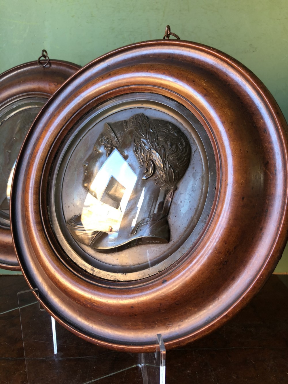 A pair of circular turned mahogany frames enclosing dark bronzed relief profile portraits of Napoleon and Marie-Louise under glass. View XIII