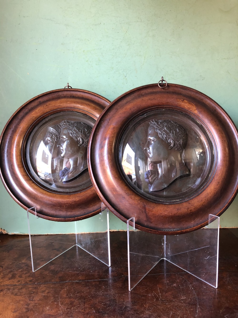 A pair of circular turned mahogany frames enclosing dark bronzed relief profile portraits of Napoleon and Marie-Louise under glass. View XV