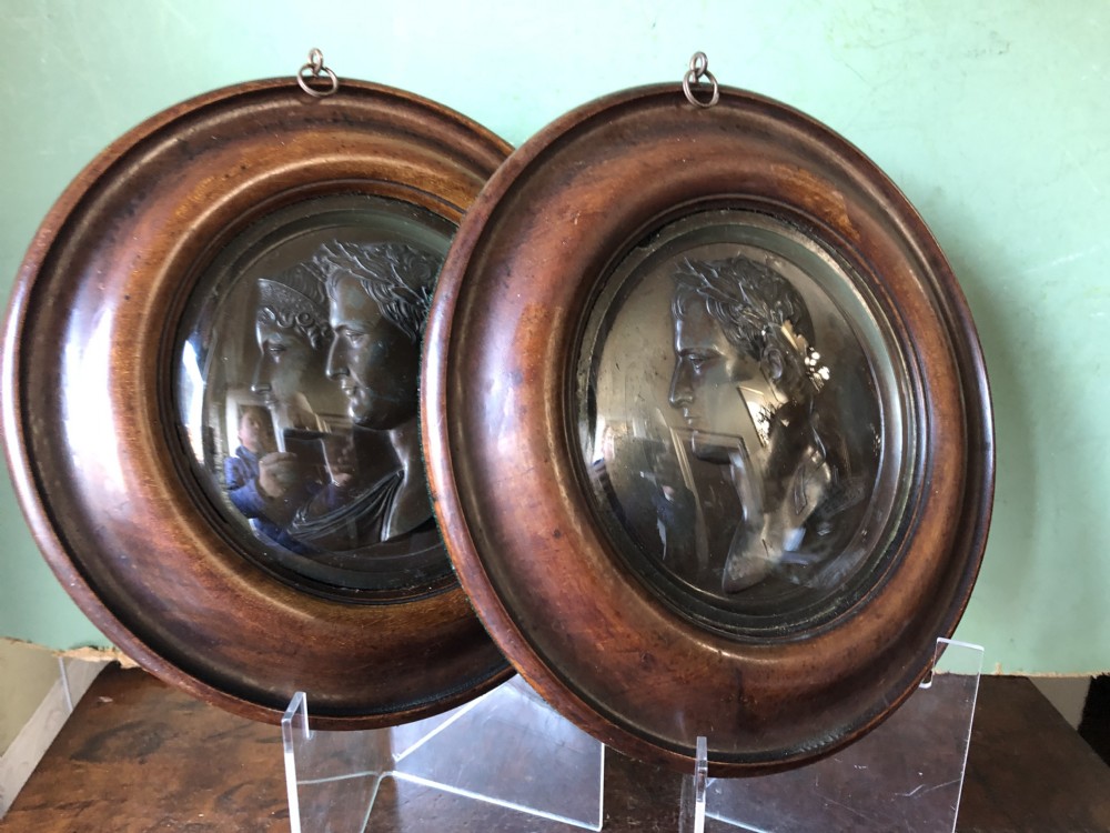 A pair of circular turned mahogany frames enclosing dark bronzed relief profile portraits of Napoleon and Marie-Louise under glass. View XVI