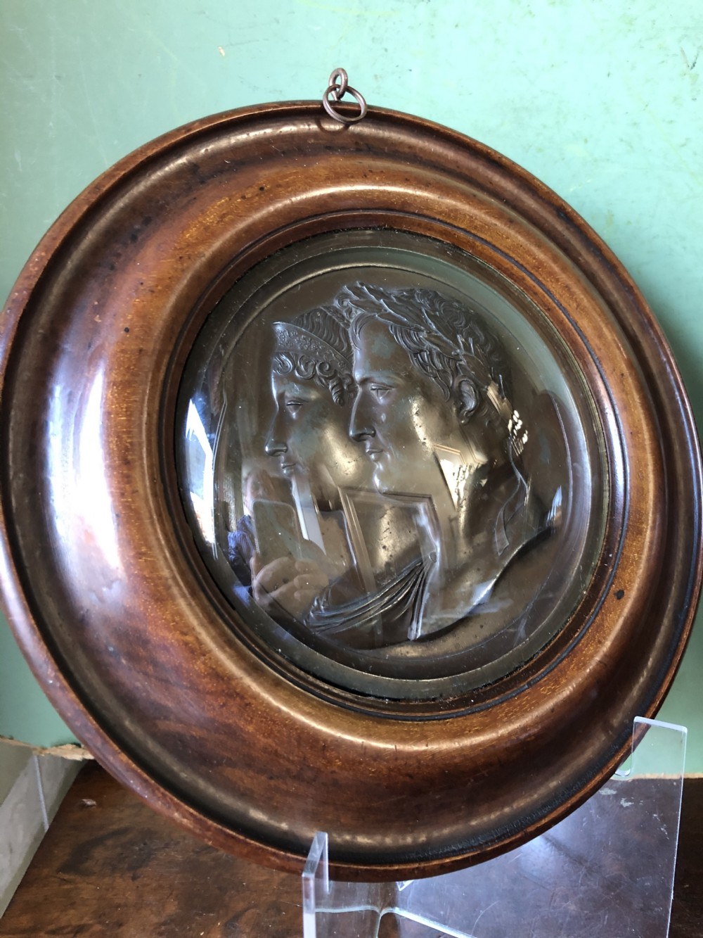 A pair of circular turned mahogany frames enclosing dark bronzed relief profile portraits of Napoleon and Marie-Louise under glass. View XVII