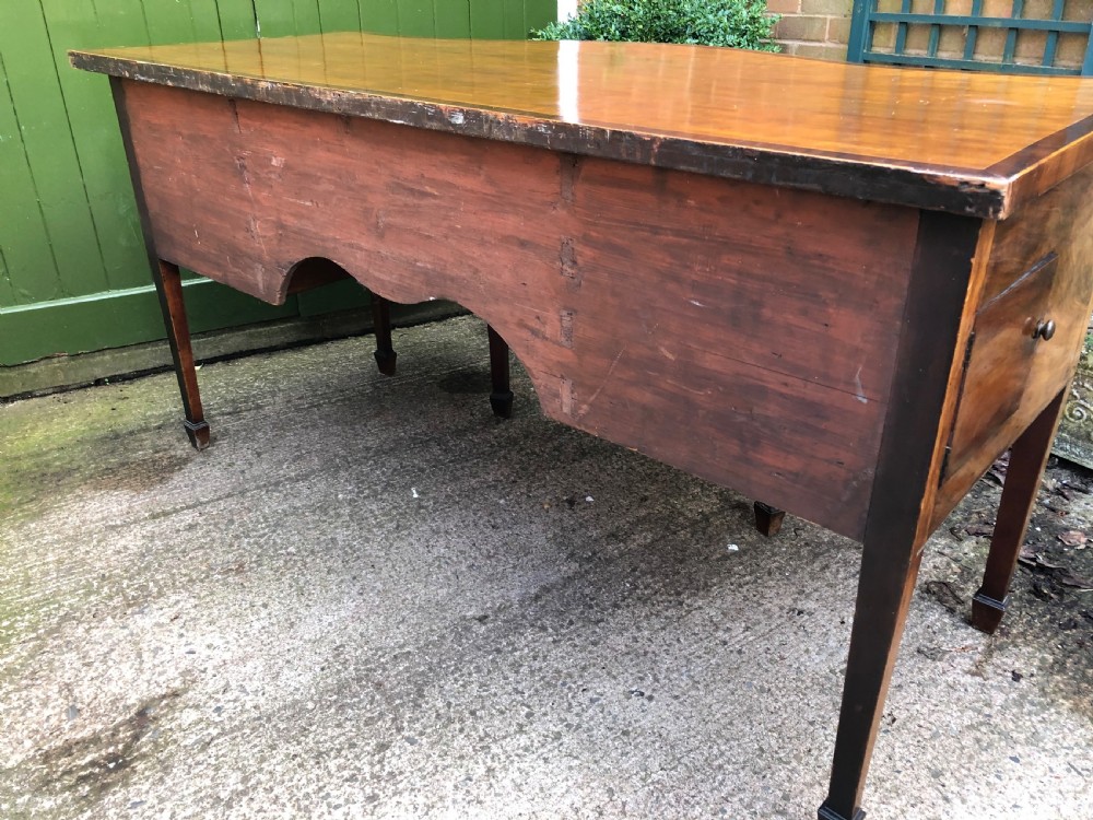 A late 18th-century George III mahogany sideboard featuring a serpentine front, floral marquetry inlay, tapering square legs with spade feet, and brass oval handles. View XXI
