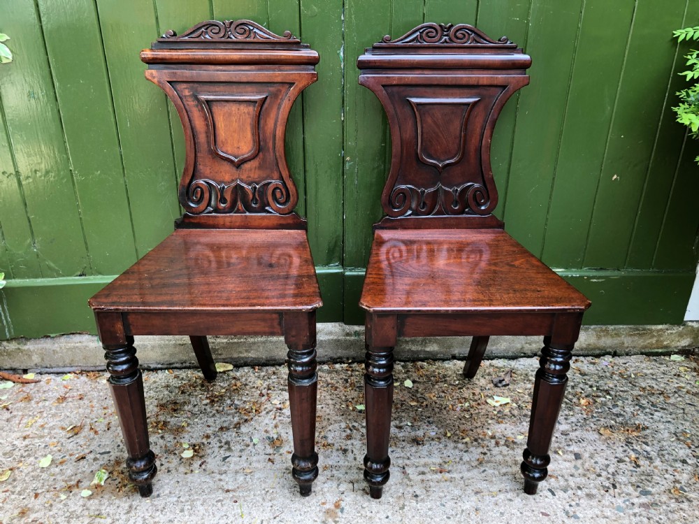 Pair of early C19th George IV period mahogany hall chairs of Grecian revival design. View II