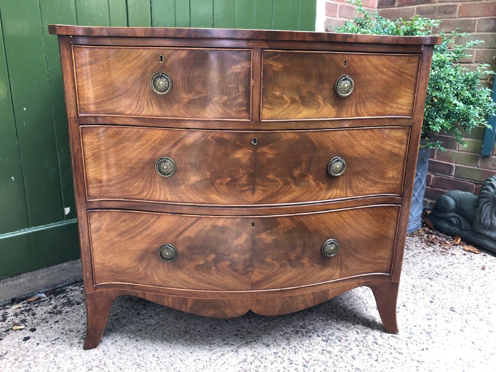 Early C19th Regency period mahogany serpentine-outline chest of drawers .