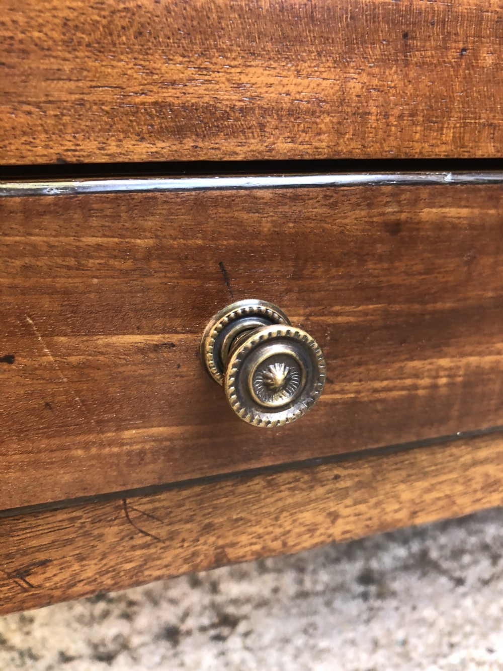 A late George III mahogany canterbury featuring slatted dividers, a concave top crest rail, a single base drawer with brass knobs, and square legs ending in brass castors. View XIV