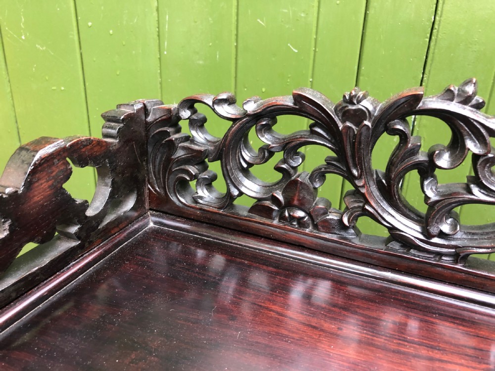 A dark rosewood late nineteenth-century Chinese display cabinet featuring intricate openwork carving throughout tiered open shelves and a crest rail. View VI
