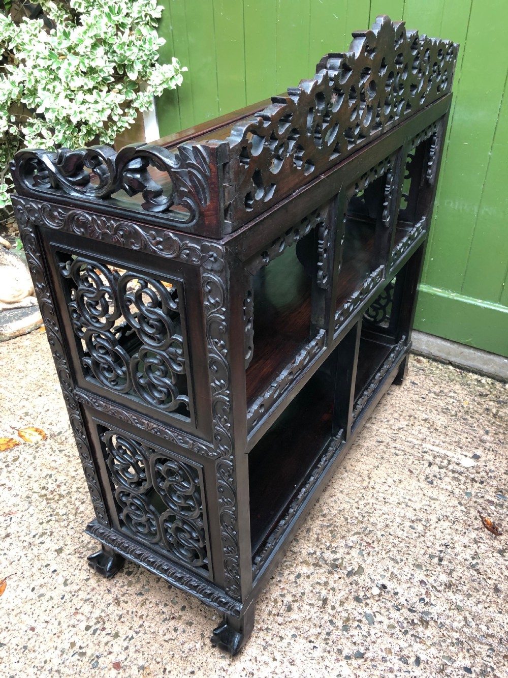 A dark rosewood late nineteenth-century Chinese display cabinet featuring intricate openwork carving throughout tiered open shelves and a crest rail. View XIV