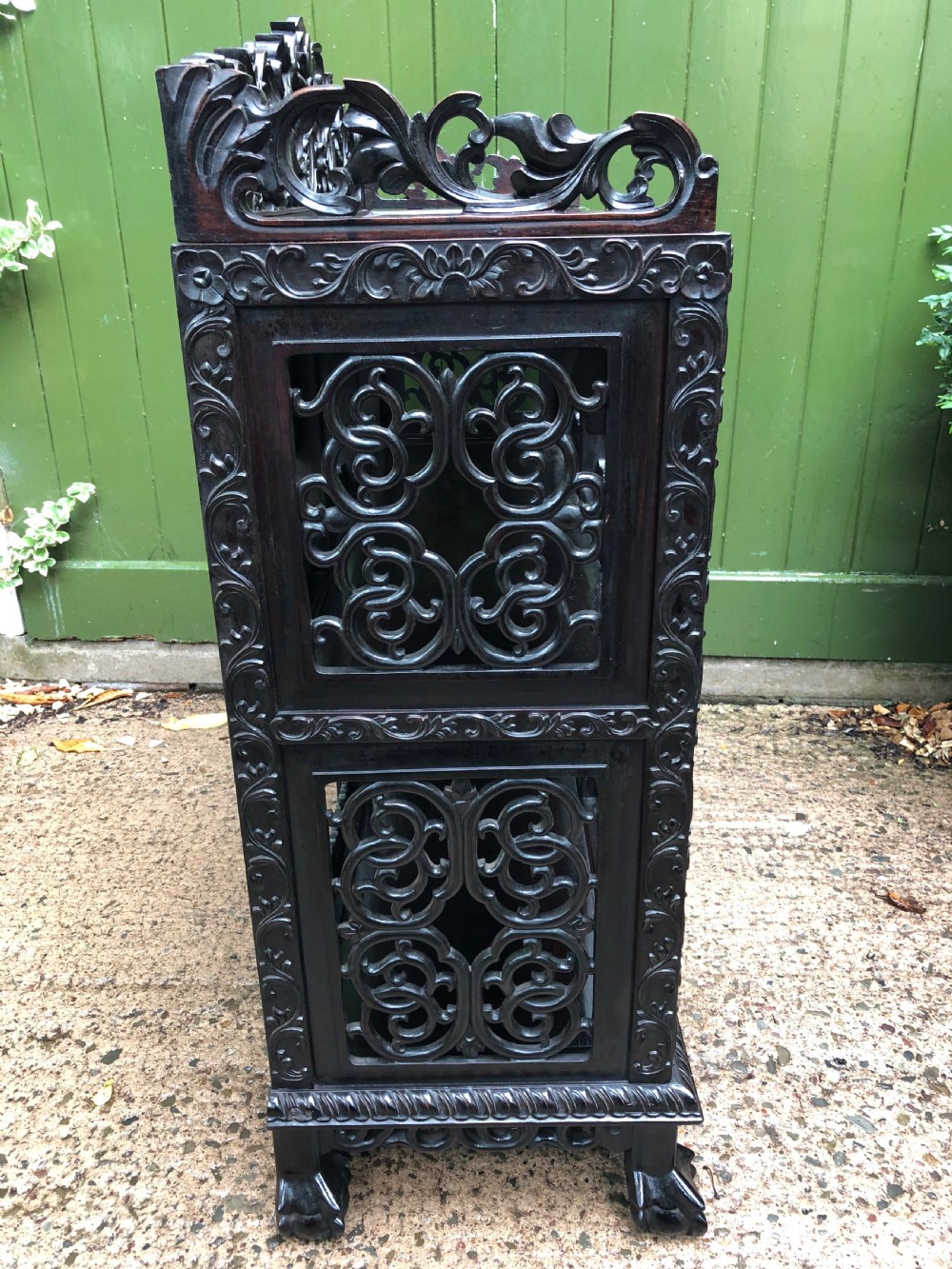 A dark rosewood late nineteenth-century Chinese display cabinet featuring intricate openwork carving throughout tiered open shelves and a crest rail. View XV