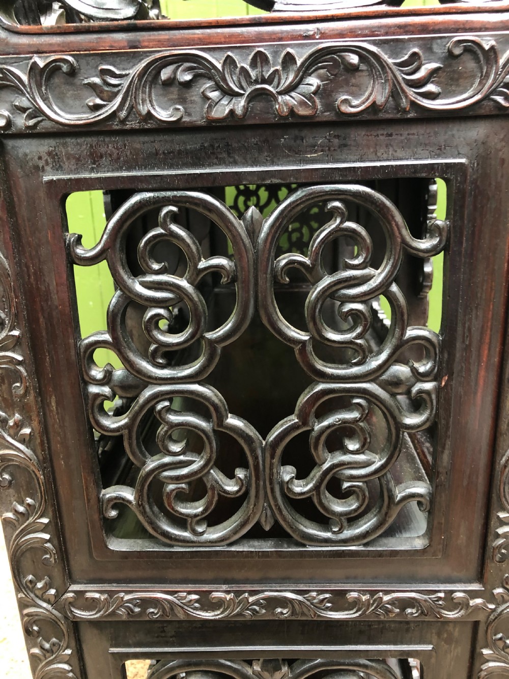 A dark rosewood late nineteenth-century Chinese display cabinet featuring intricate openwork carving throughout tiered open shelves and a crest rail. View XVII