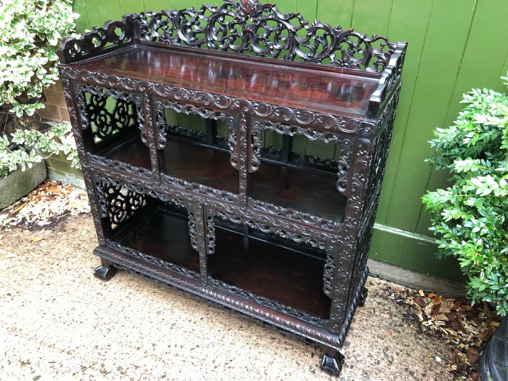A dark rosewood late nineteenth-century Chinese display cabinet featuring intricate openwork carving throughout tiered open shelves and a crest rail. View XXII
