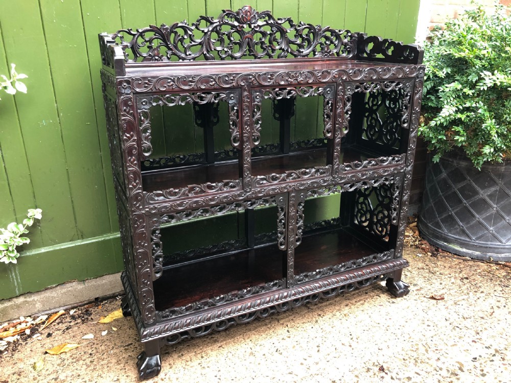 A dark rosewood late nineteenth-century Chinese display cabinet featuring intricate openwork carving throughout tiered open shelves and a crest rail. View XXIII