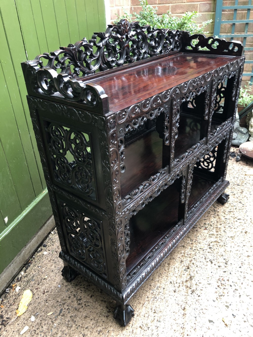 A dark rosewood late nineteenth-century Chinese display cabinet featuring intricate openwork carving throughout tiered open shelves and a crest rail. View VIII