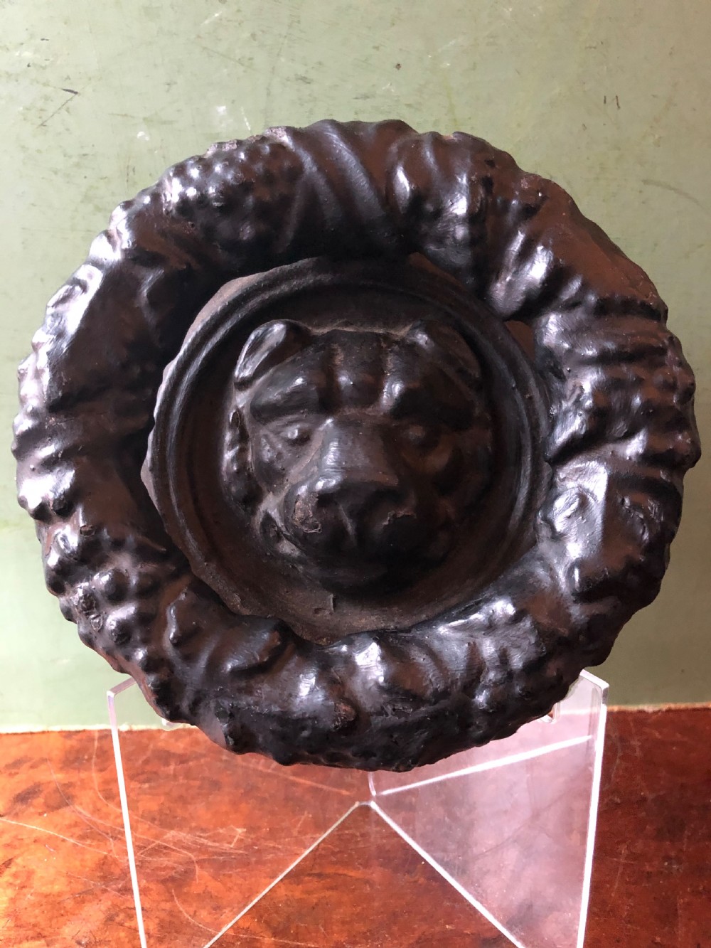 C19th Regency period cast-iron door knocker modelled as a laurel wreath ring with a leopard’s mask centre . View II