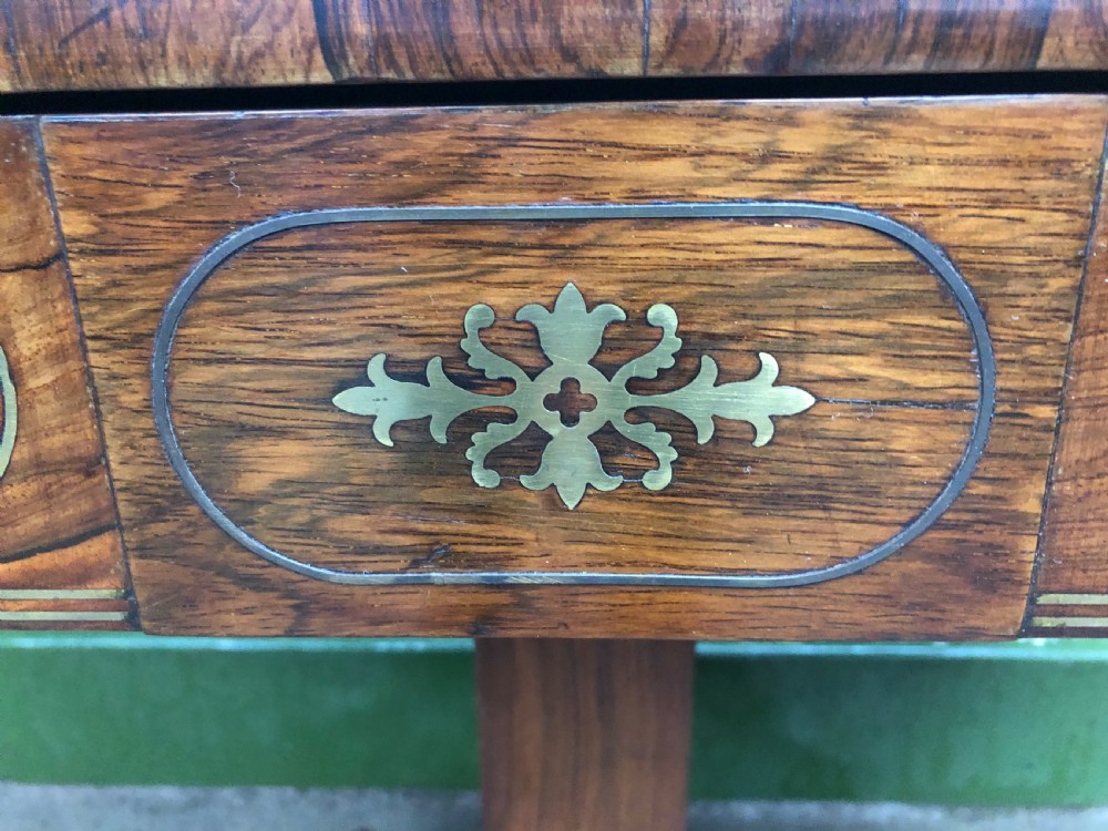 An early nineteenth-century Regency rosewood fold-over card table featuring decorative brass line inlay, a central pedestal, and splayed legs with brass claw feet. View VII