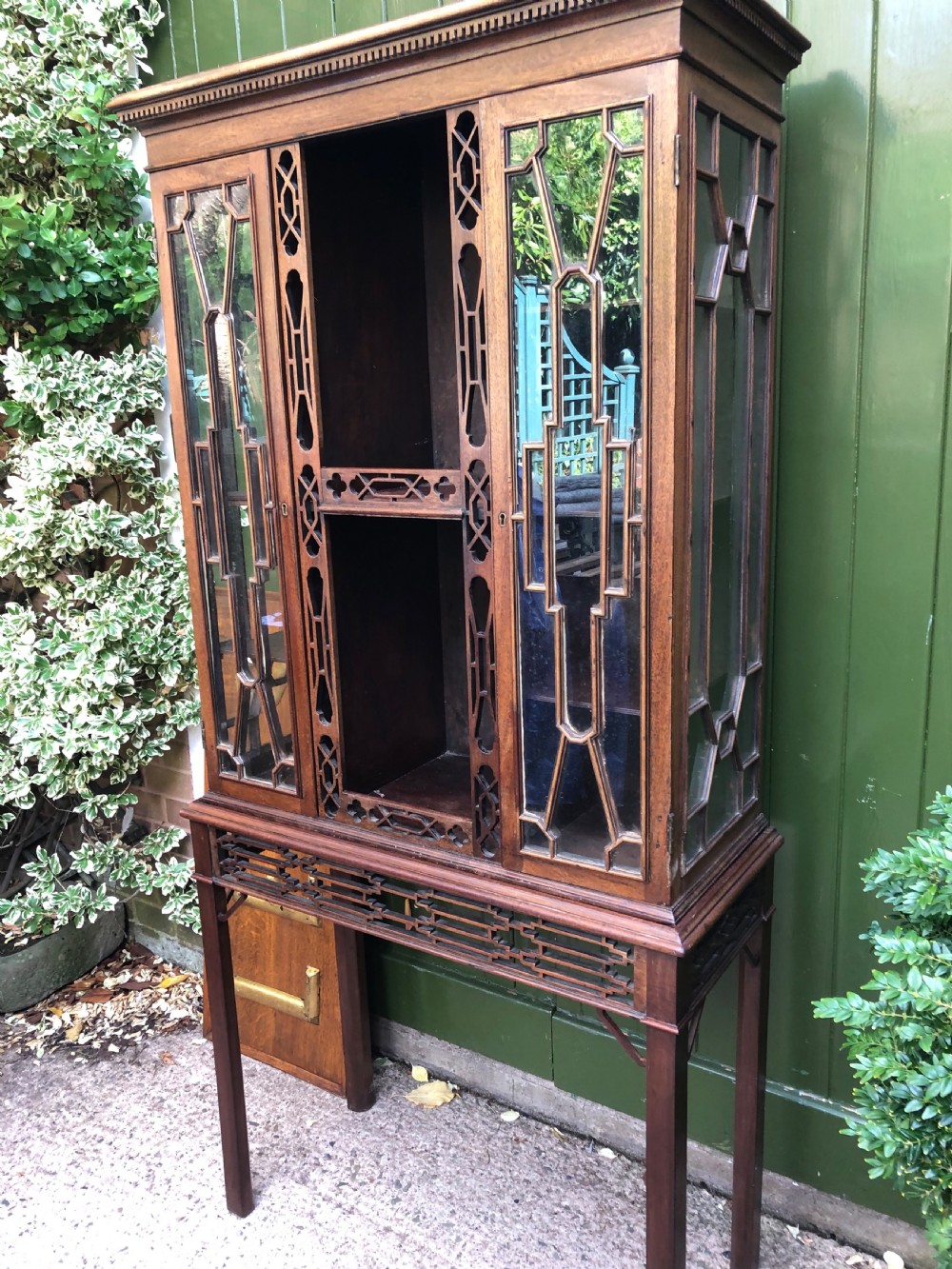 A mid-19th-century Chinese Chippendale revival mahogany glazed china display cabinet elevated on a matching stand with geometric fretwork detail. View V