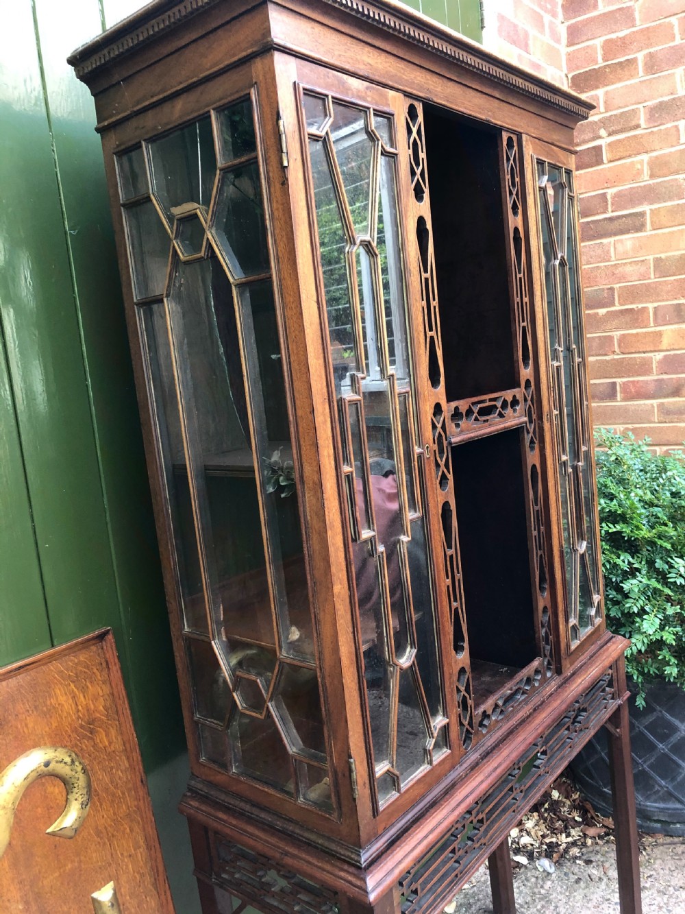 A mid-19th-century Chinese Chippendale revival mahogany glazed china display cabinet elevated on a matching stand with geometric fretwork detail. View VI