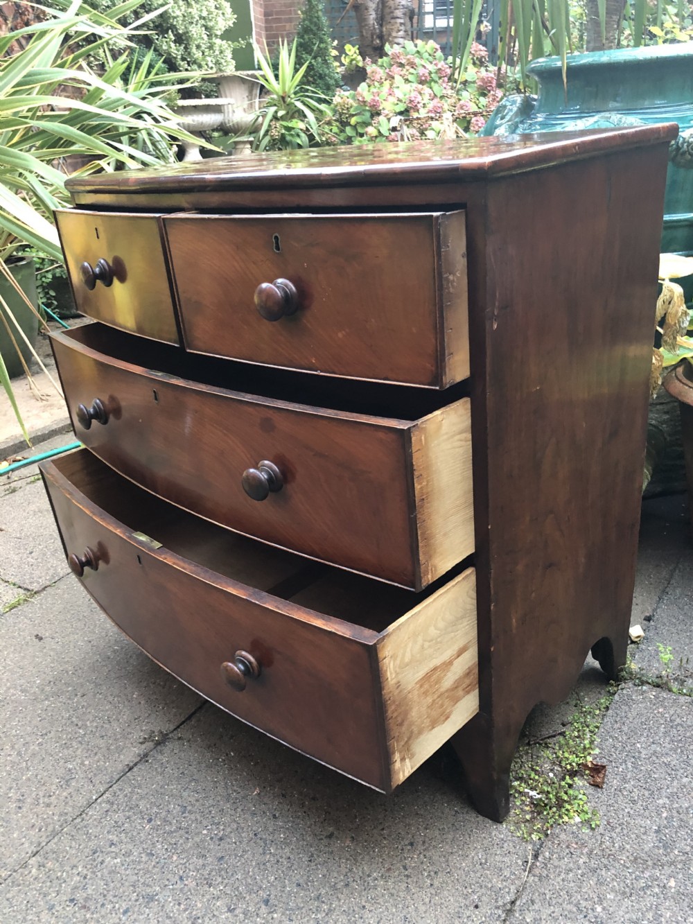 An early nineteenth-century George III mahogany bowfront chest of drawers featuring two short over two long drawers with turned knobs and splayed bracket feet. View XII