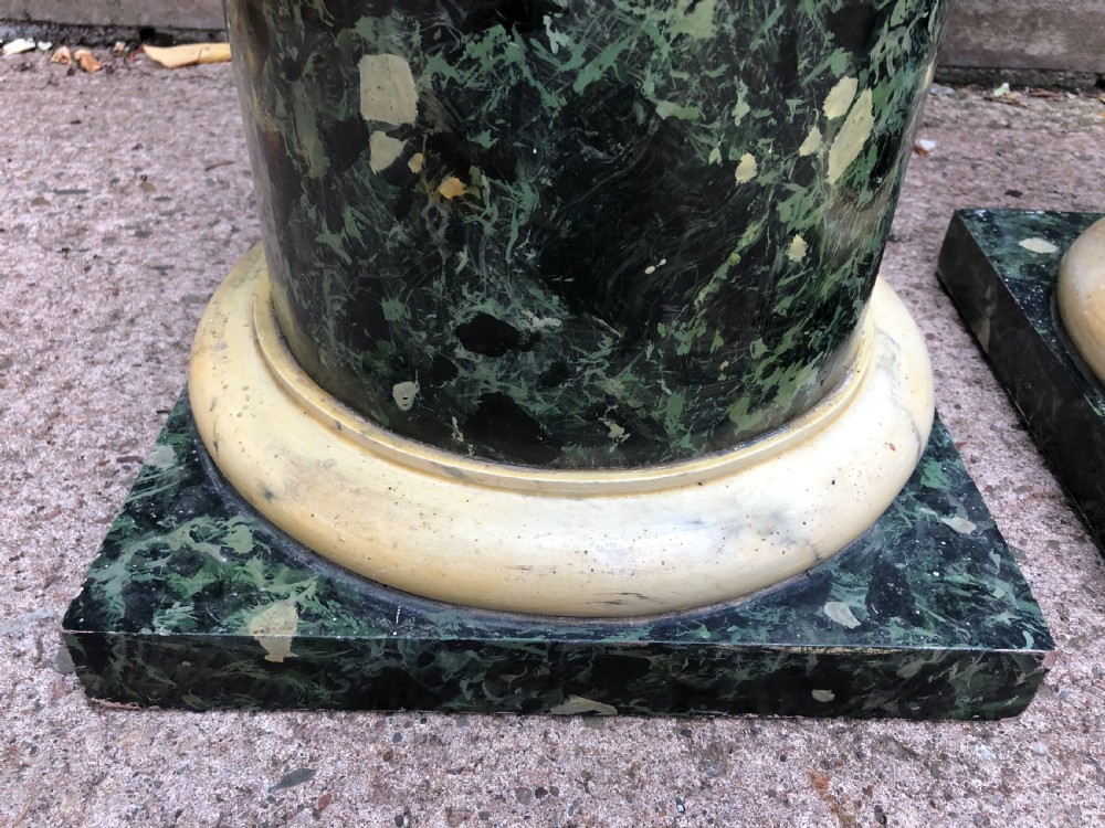 A pair of tall mid-19th century cylindrical wooden display columns painted in a green and black faux verde antico marble finish with square bases. View IX