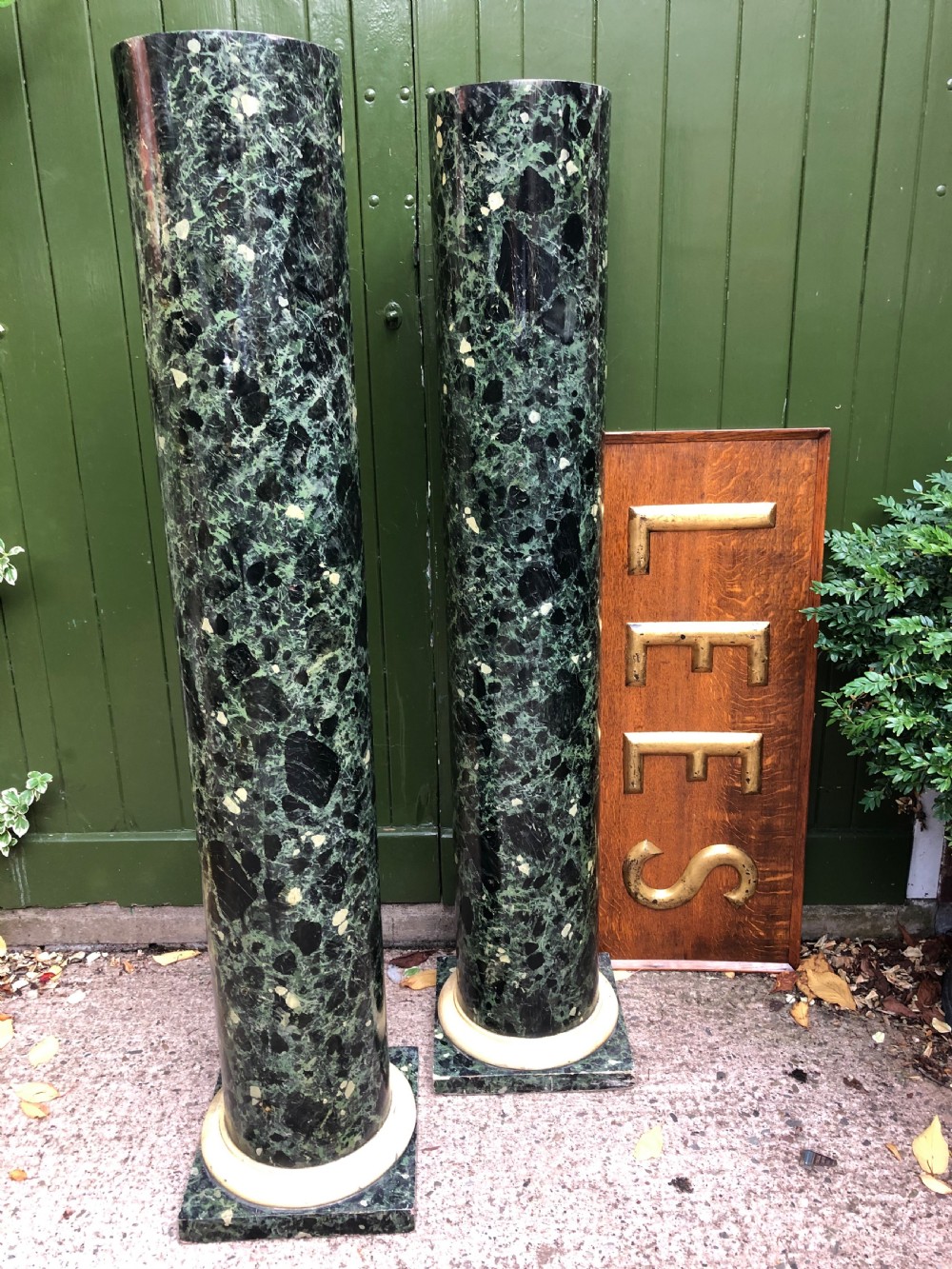 A pair of tall mid-19th century cylindrical wooden display columns painted in a green and black faux verde antico marble finish with square bases. View XIII