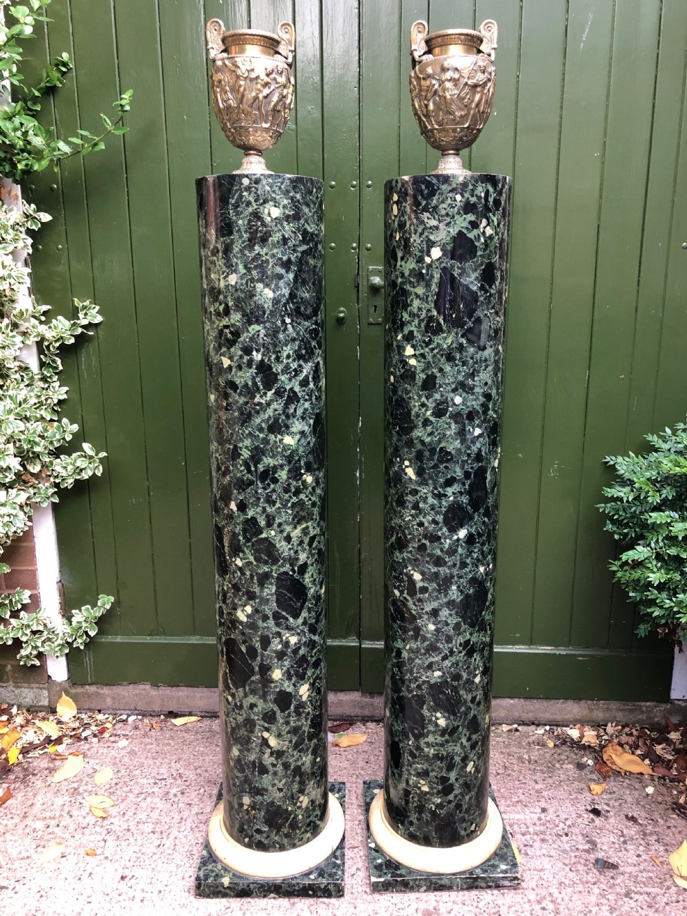 A pair of tall mid-19th century cylindrical wooden display columns painted in a green and black faux verde antico marble finish with square bases. View XXII