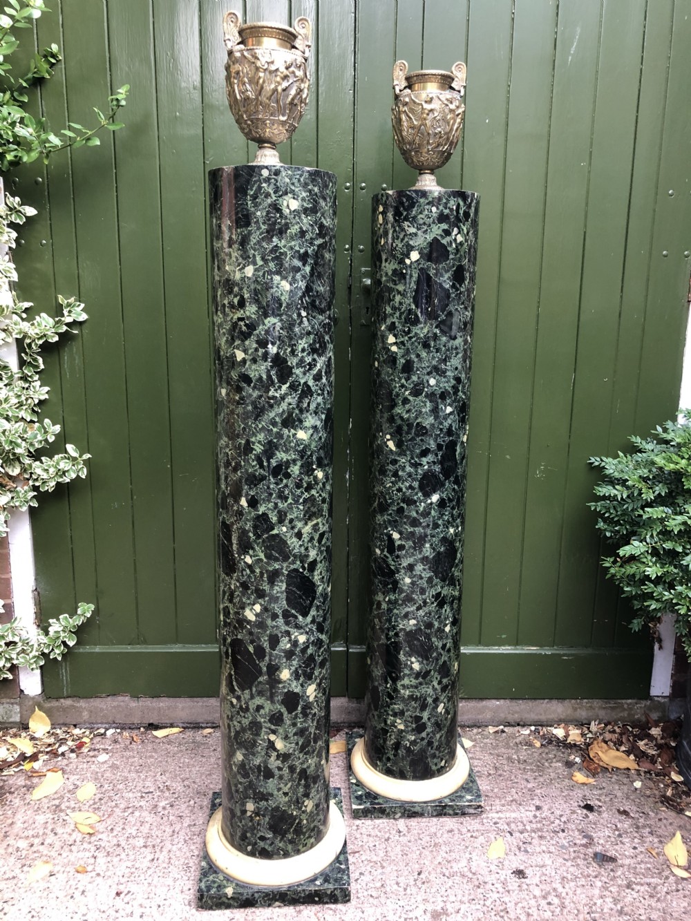 A pair of tall mid-19th century cylindrical wooden display columns painted in a green and black faux verde antico marble finish with square bases. View III