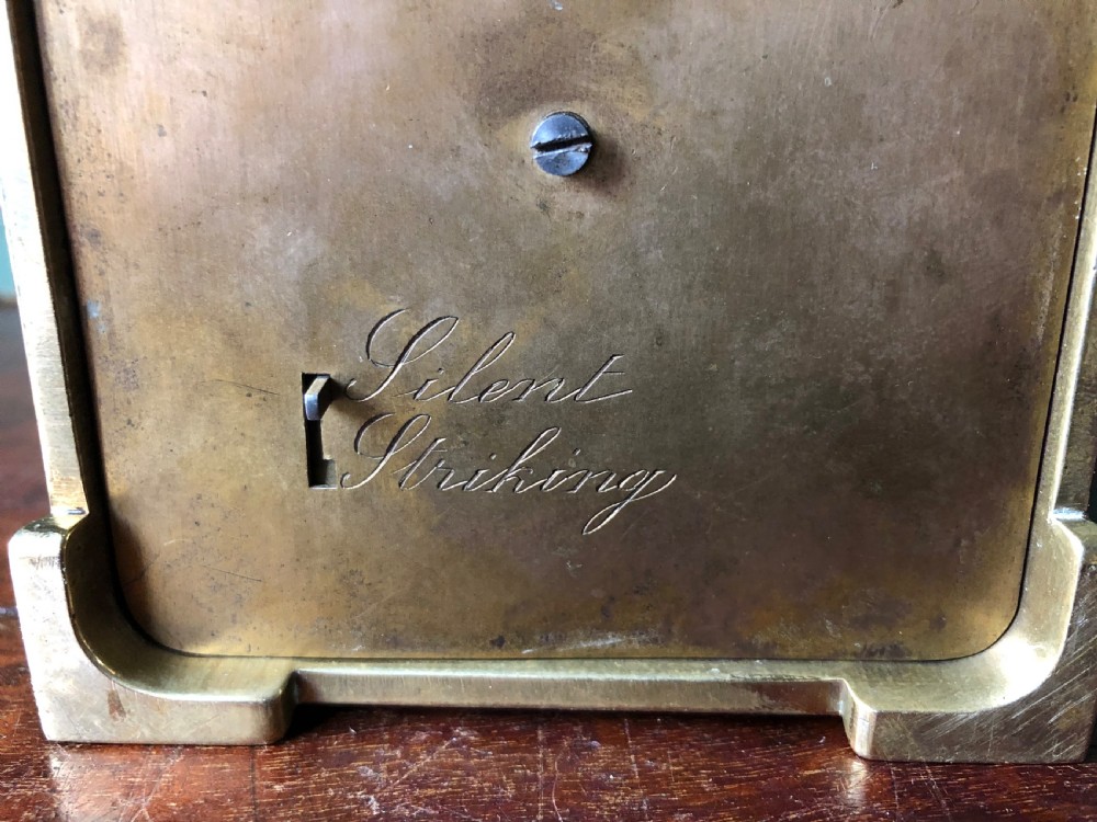 A late nineteenth-century French gilt brass carriage clock featuring fluted Corinthian corner columns, a carrying handle, a central dial with Arabic numerals, a lower subsidiary dial, and an adjacent winding key. View XV