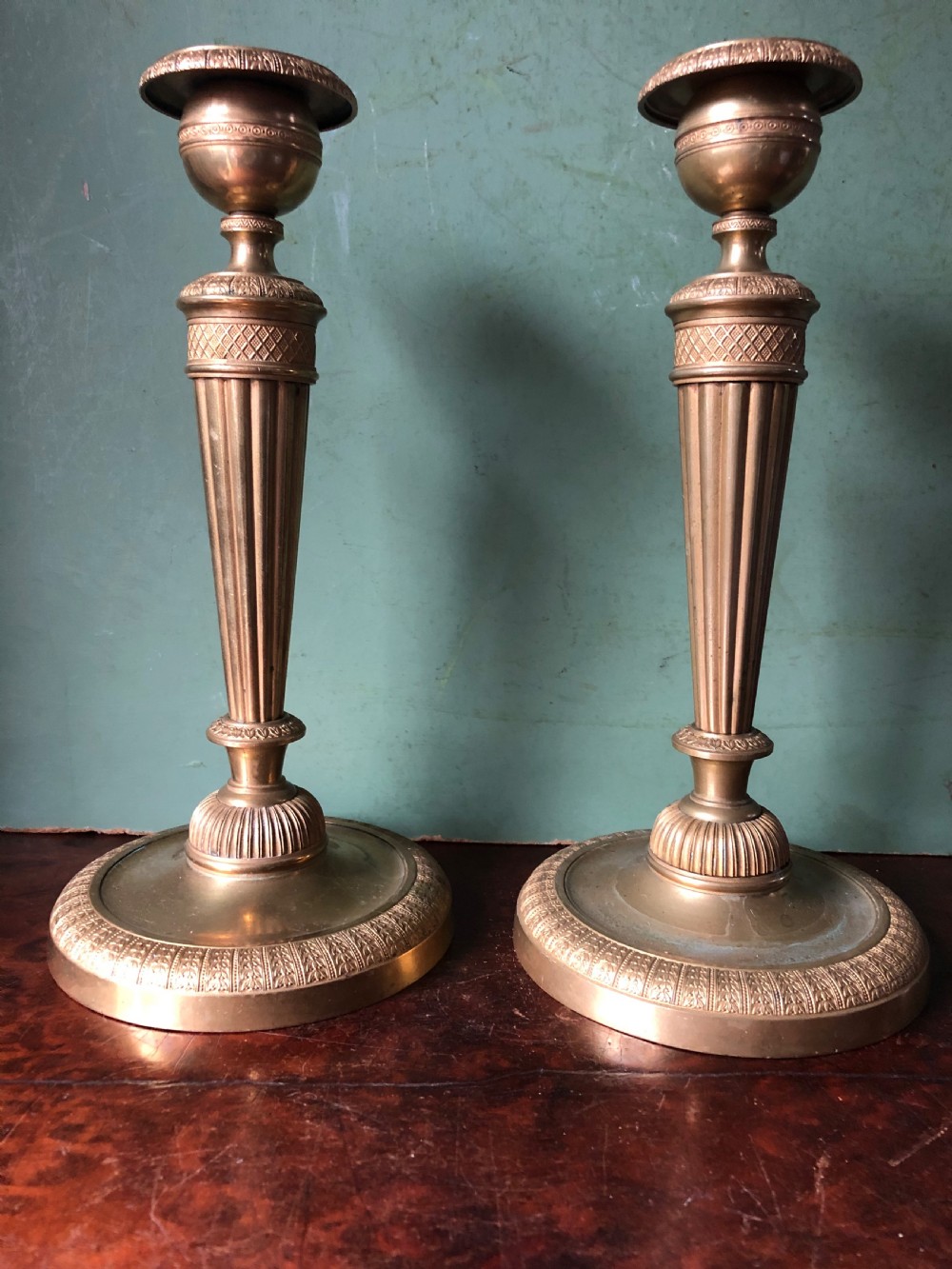 A pair of early 19th-century French Charles X period gilded bronze ormolu candlesticks with fluted columns and detailed engine-turned bases. View II