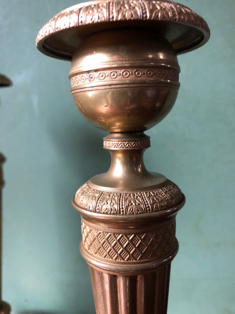 A pair of early 19th-century French Charles X period gilded bronze ormolu candlesticks with fluted columns and detailed engine-turned bases. View V