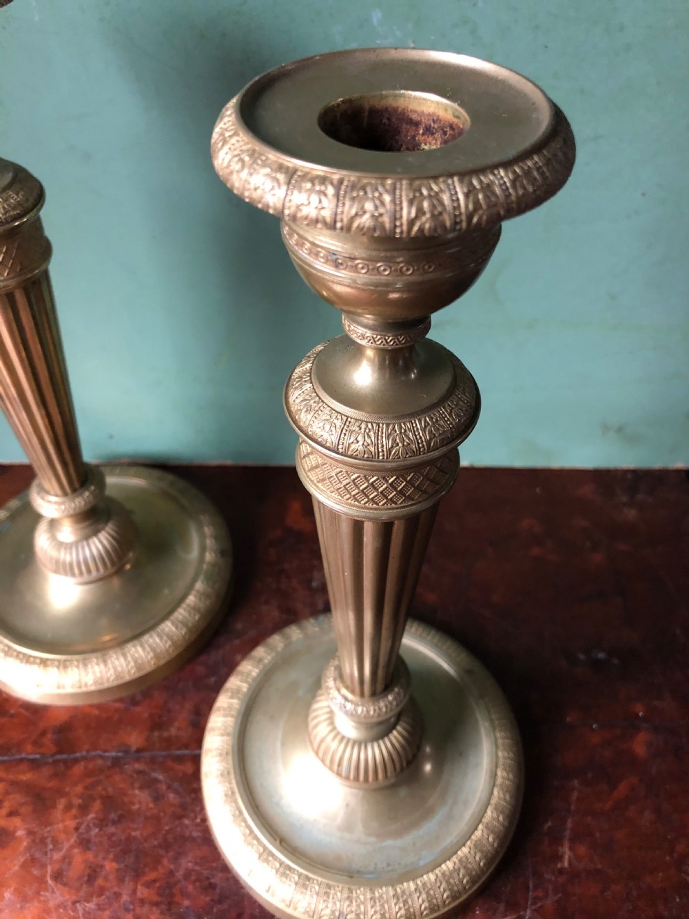 A pair of early 19th-century French Charles X period gilded bronze ormolu candlesticks with fluted columns and detailed engine-turned bases. View VI