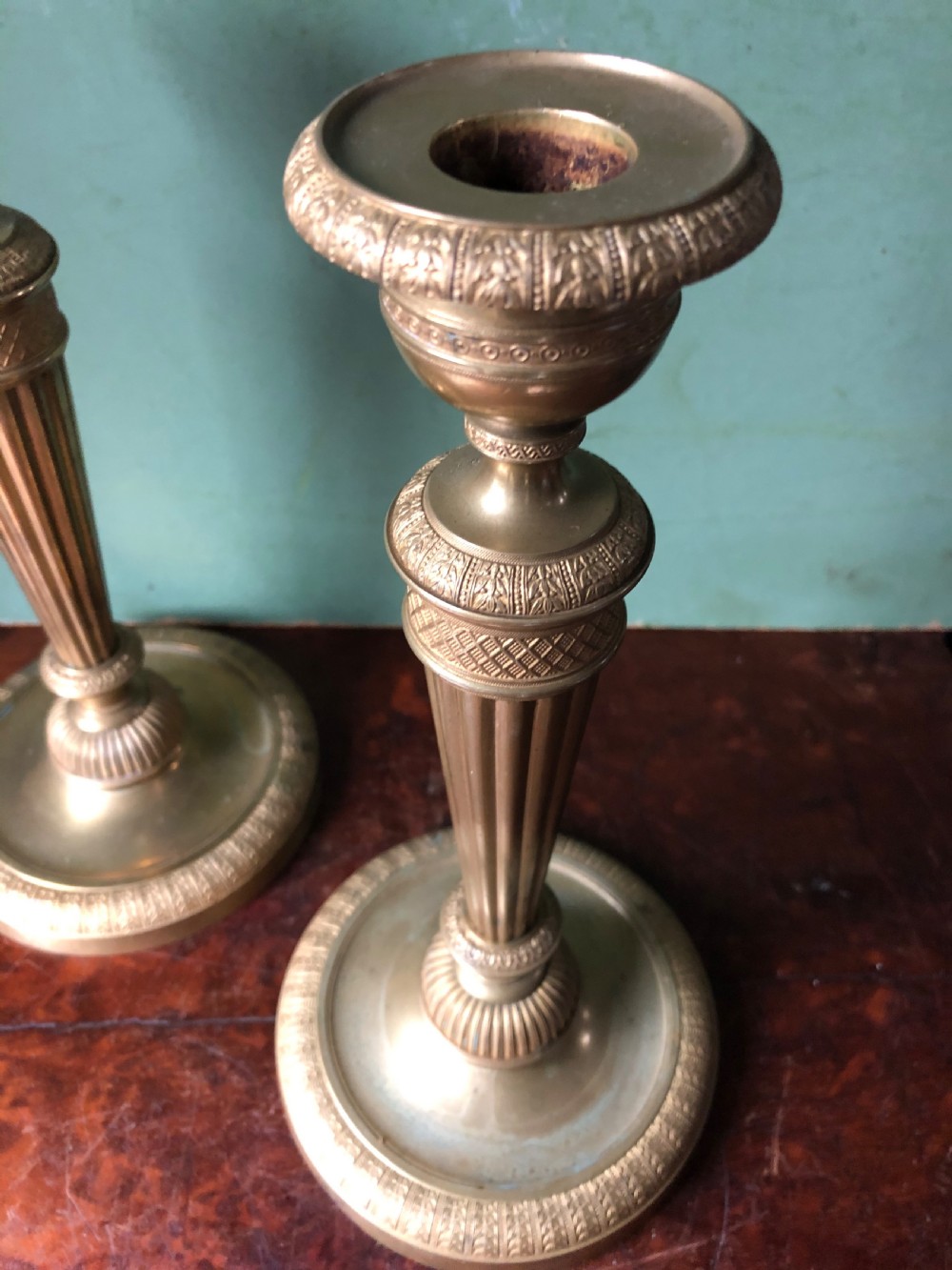 A pair of early 19th-century French Charles X period gilded bronze ormolu candlesticks with fluted columns and detailed engine-turned bases. View VII