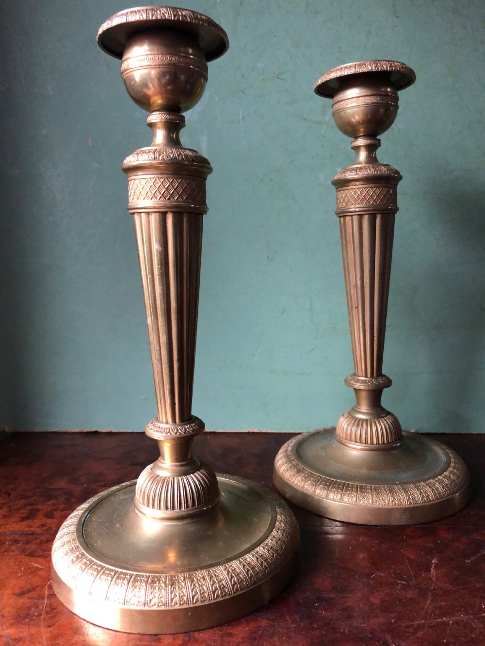 A pair of early 19th-century French Charles X period gilded bronze ormolu candlesticks with fluted columns and detailed engine-turned bases. View VIII