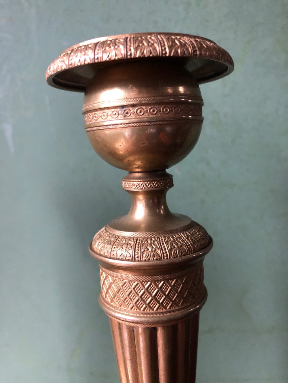 A pair of early 19th-century French Charles X period gilded bronze ormolu candlesticks with fluted columns and detailed engine-turned bases. View IX