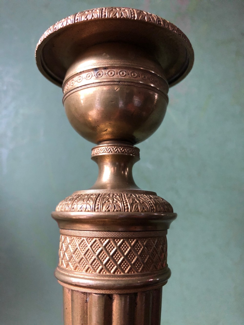 A pair of early 19th-century French Charles X period gilded bronze ormolu candlesticks with fluted columns and detailed engine-turned bases. View XIII