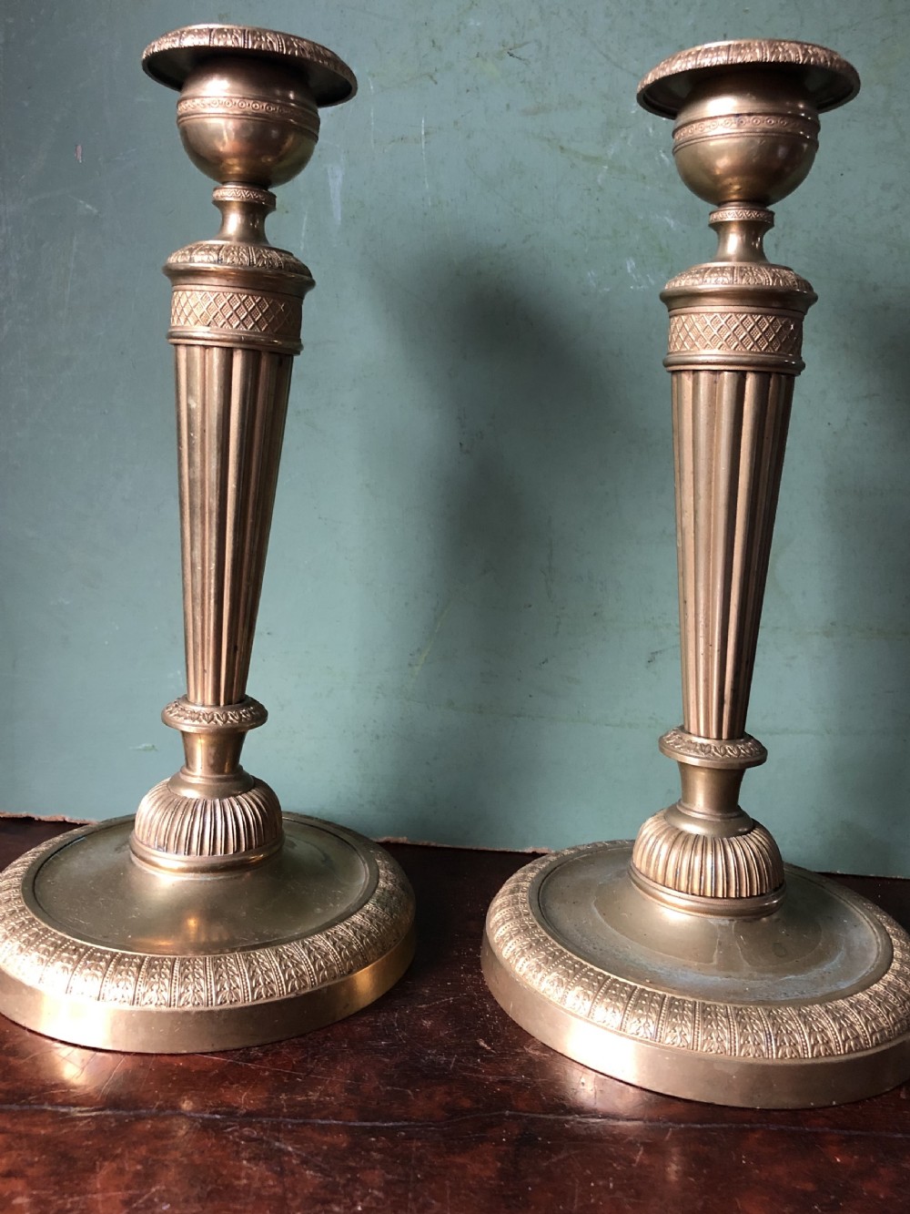 A pair of early 19th-century French Charles X period gilded bronze ormolu candlesticks with fluted columns and detailed engine-turned bases. View XVIII