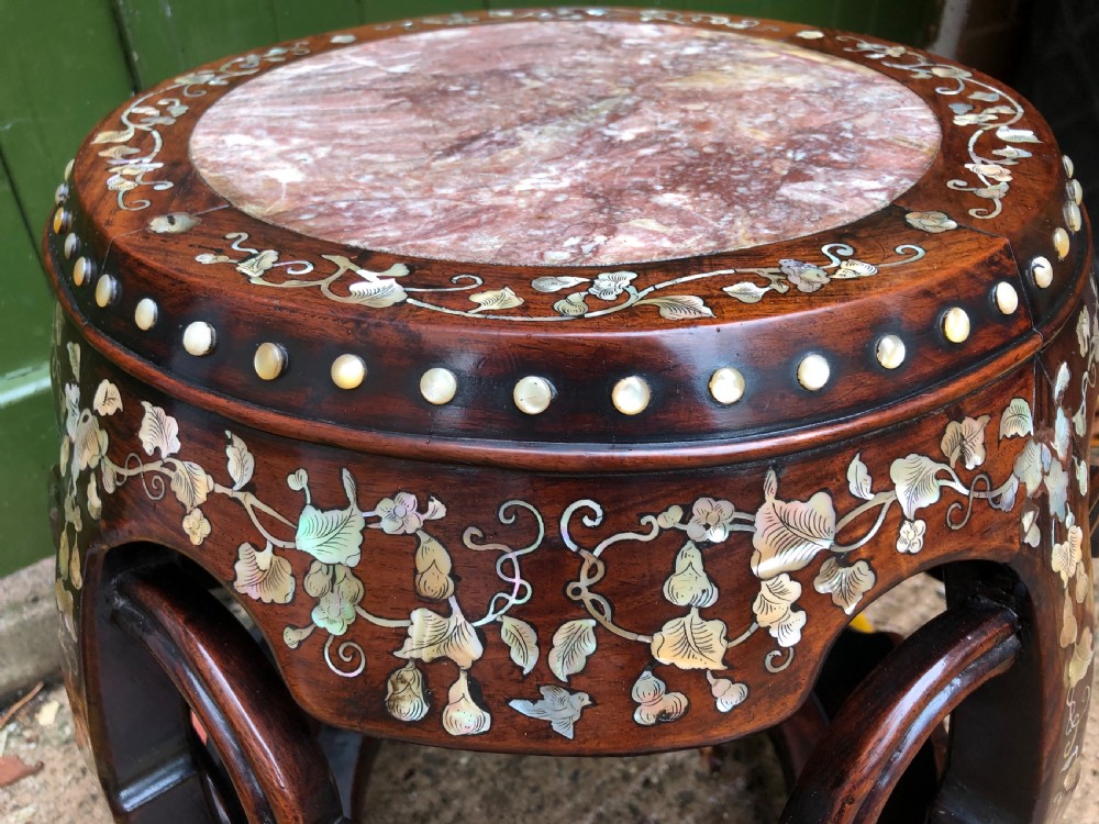 A nineteenth-century Chinese dark hongmu drum-shaped stool decorated with mother-of-pearl floral inlay and carved openwork sides. View X