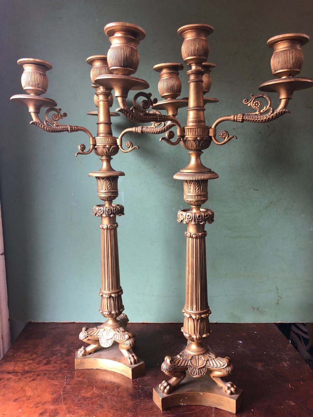 A pair of early nineteenth-century French Charles X gilt bronze candelabras featuring fluted columns, ornate scrolled arms, and decorative leaf motifs. View III