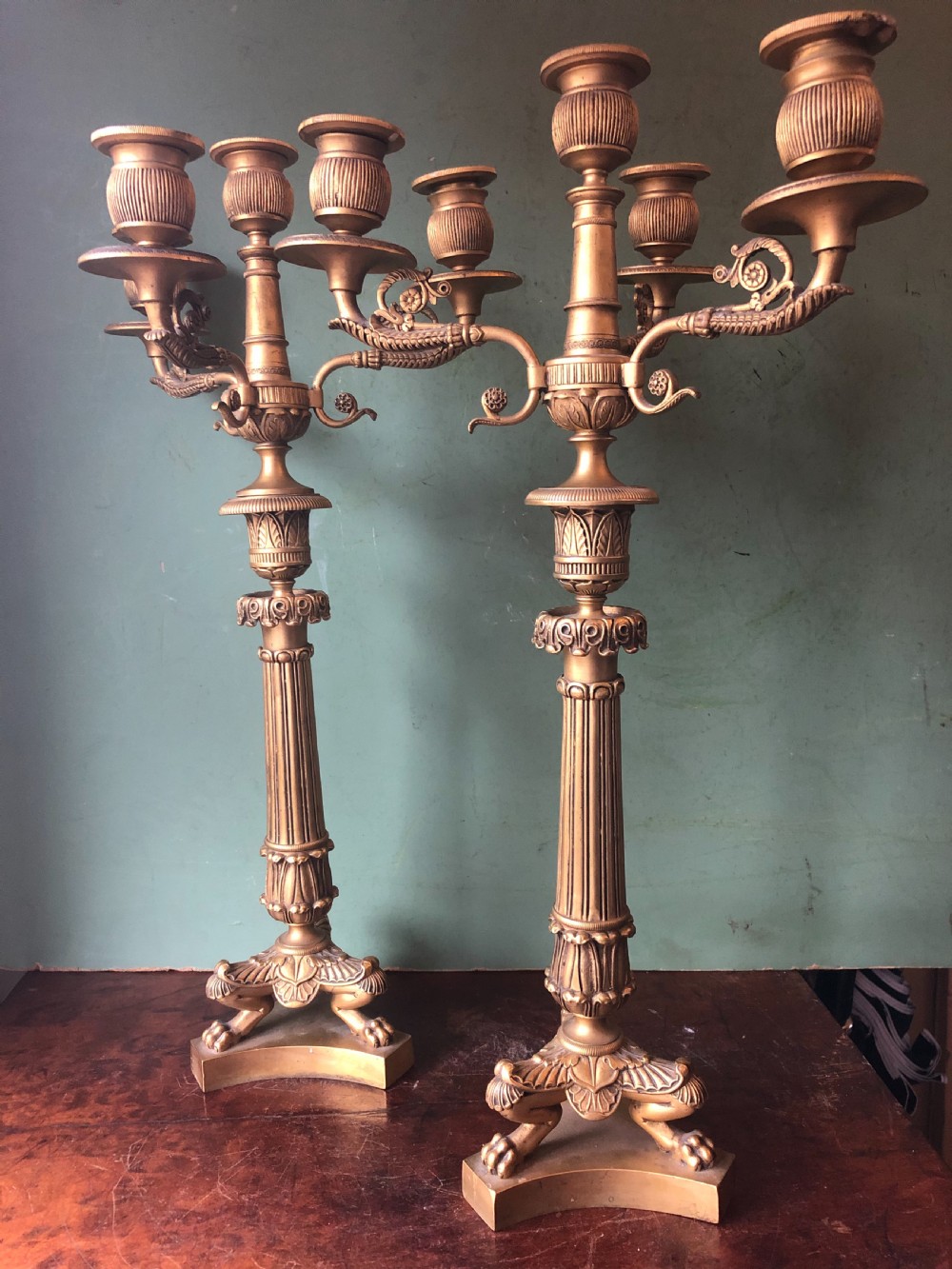 A pair of early nineteenth-century French Charles X gilt bronze candelabras featuring fluted columns, ornate scrolled arms, and decorative leaf motifs. View IV