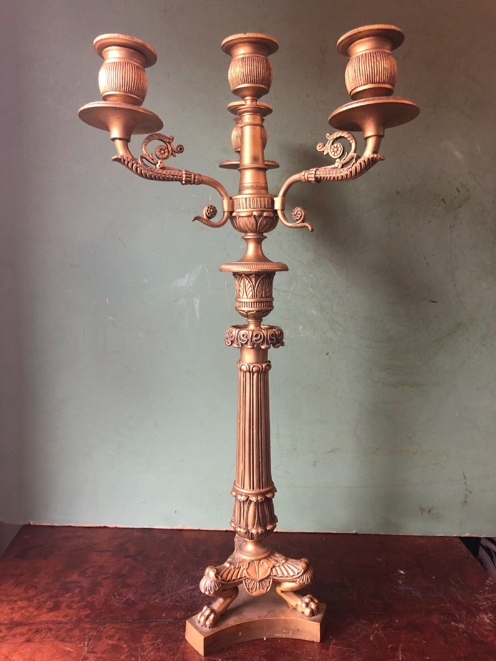 A pair of early nineteenth-century French Charles X gilt bronze candelabras featuring fluted columns, ornate scrolled arms, and decorative leaf motifs. View VII