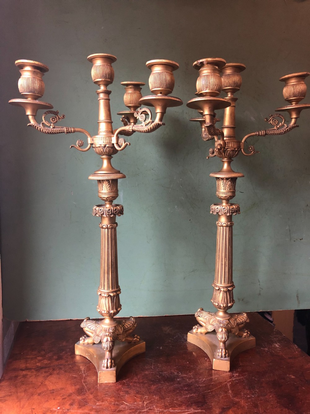 A pair of early nineteenth-century French Charles X gilt bronze candelabras featuring fluted columns, ornate scrolled arms, and decorative leaf motifs. View IX
