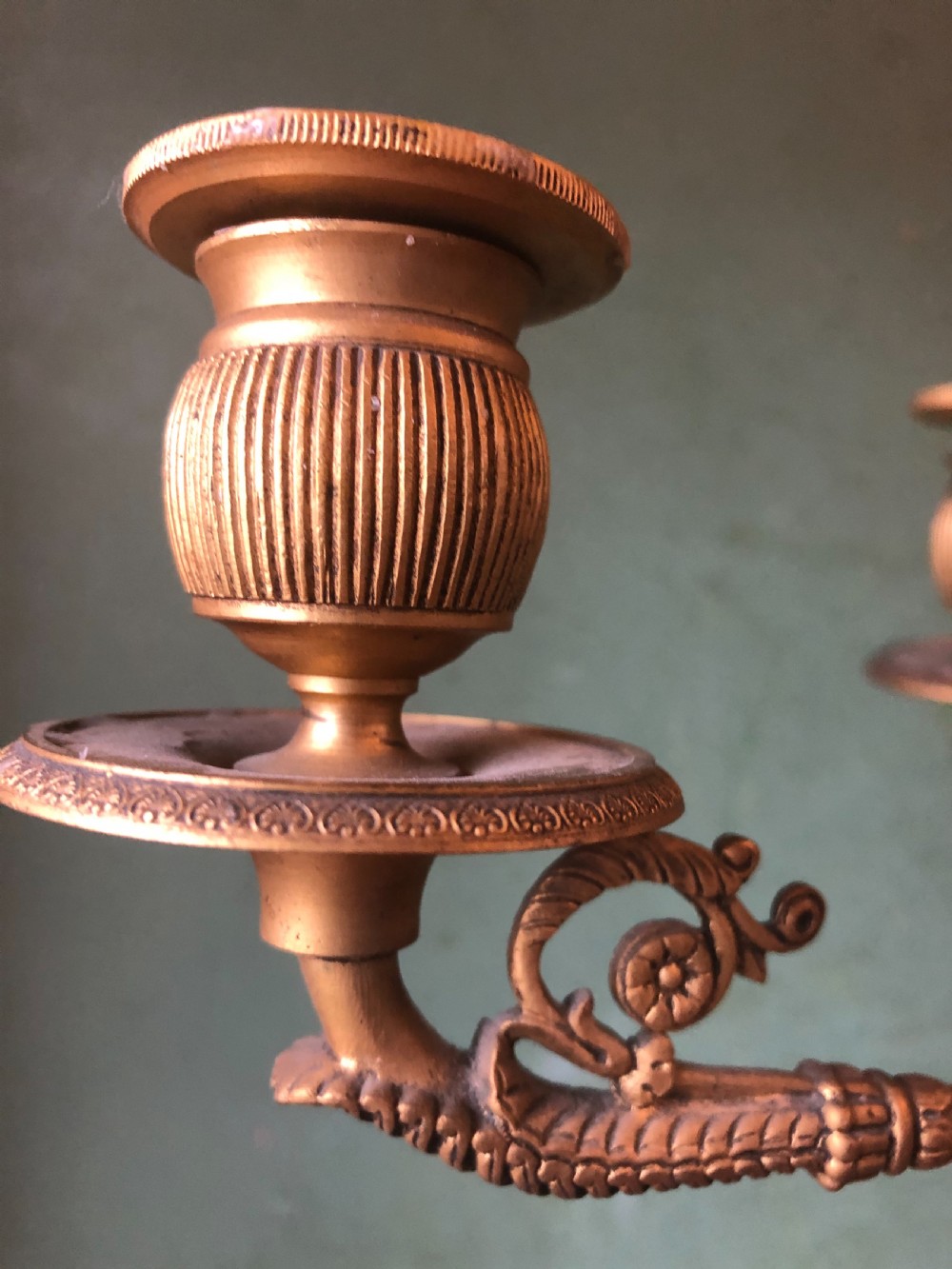 A pair of early nineteenth-century French Charles X gilt bronze candelabras featuring fluted columns, ornate scrolled arms, and decorative leaf motifs. View X