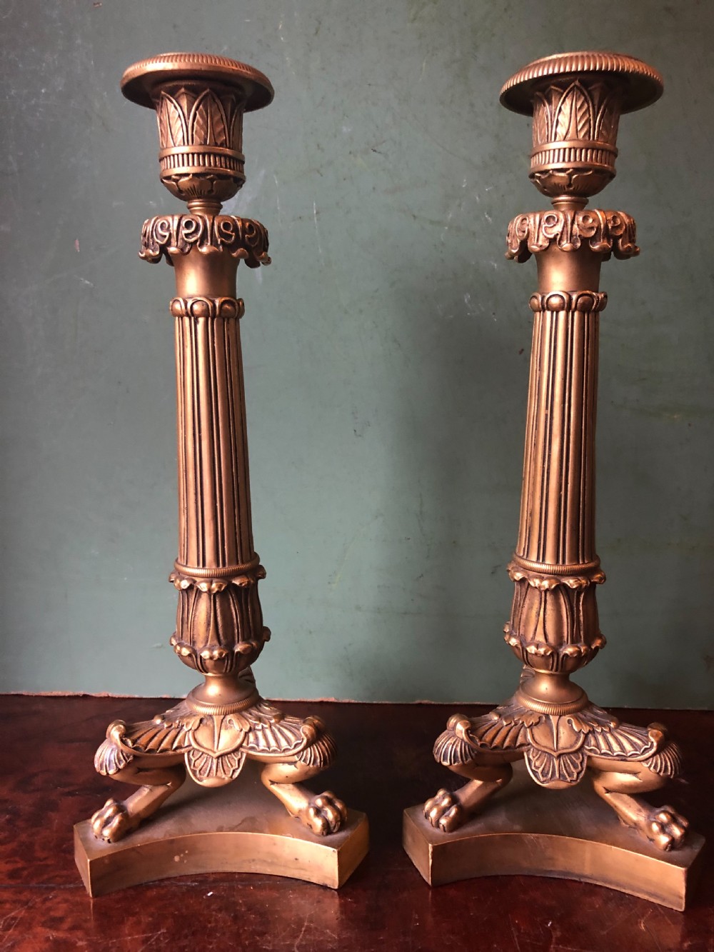 A pair of early nineteenth-century French Charles X gilt bronze candelabras featuring fluted columns, ornate scrolled arms, and decorative leaf motifs. View XIII