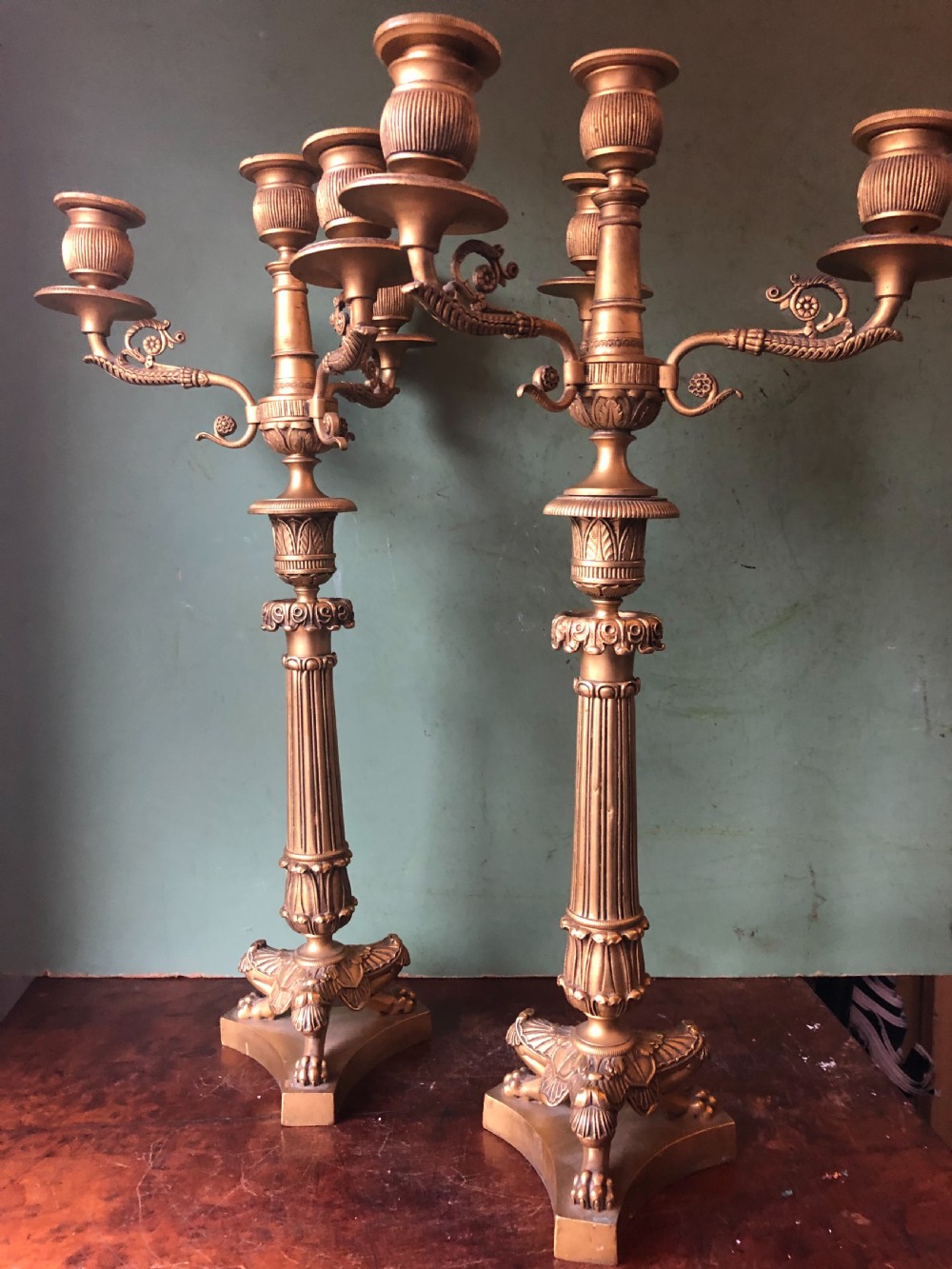 A pair of early nineteenth-century French Charles X gilt bronze candelabras featuring fluted columns, ornate scrolled arms, and decorative leaf motifs. View XVI