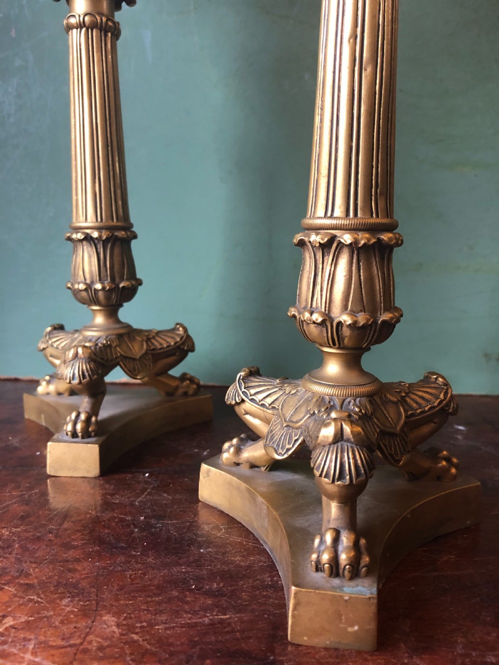 A pair of early nineteenth-century French Charles X gilt bronze candelabras featuring fluted columns, ornate scrolled arms, and decorative leaf motifs. View XIX