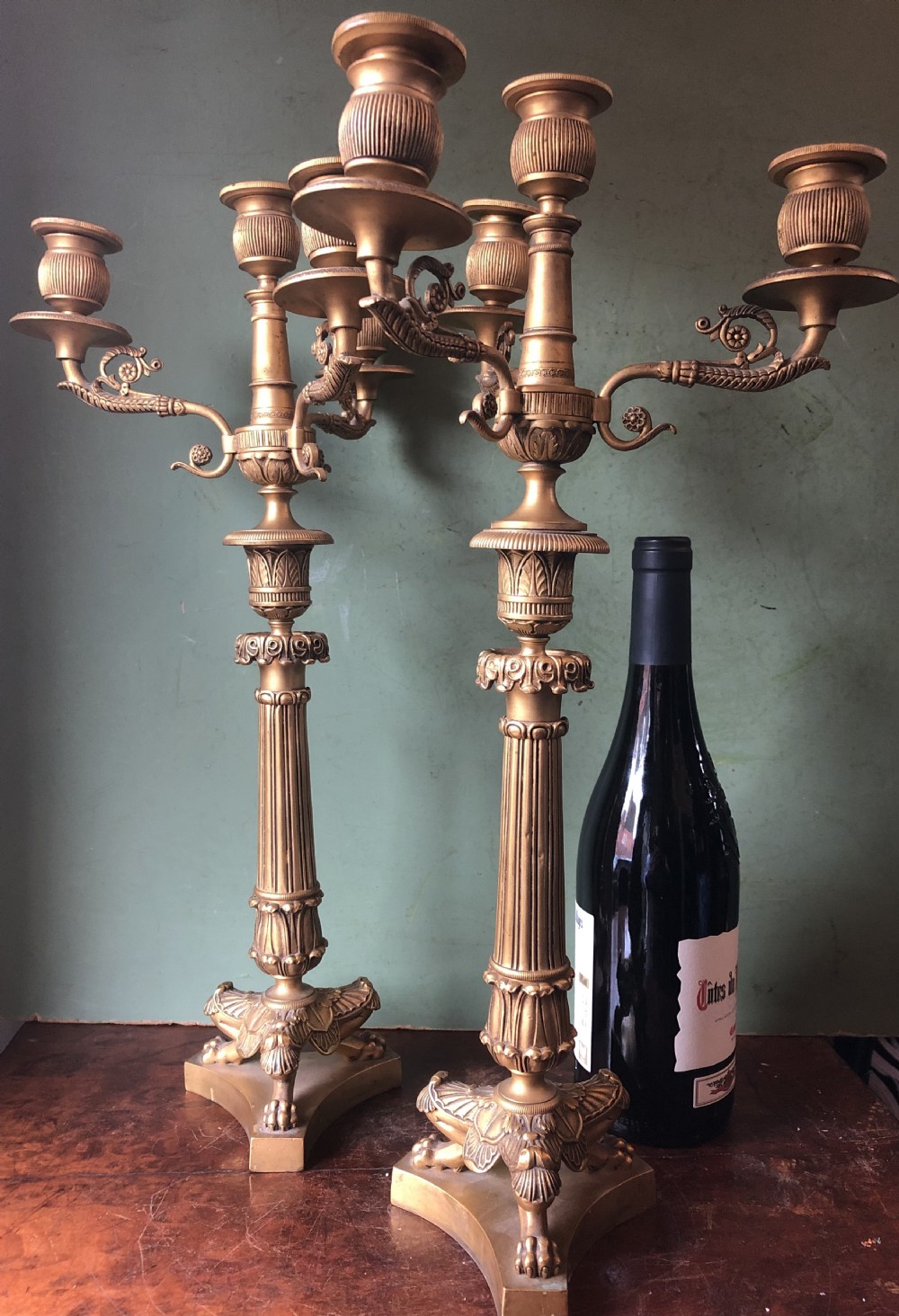 A pair of early nineteenth-century French Charles X gilt bronze candelabras featuring fluted columns, ornate scrolled arms, and decorative leaf motifs. View XVIII
