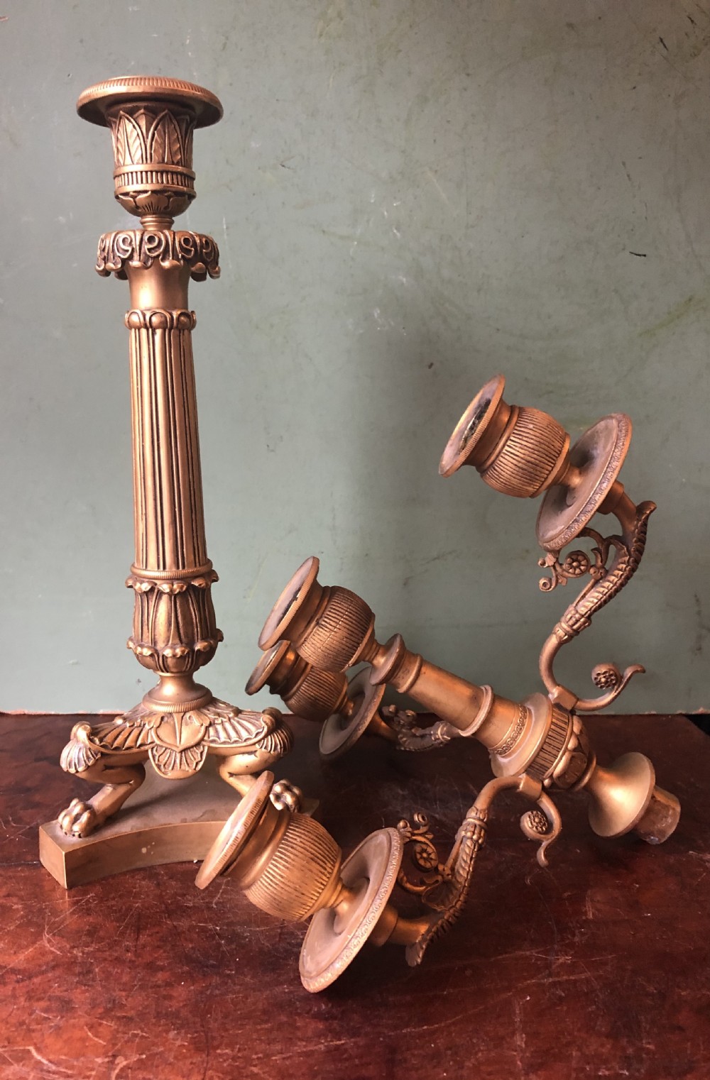 A pair of early nineteenth-century French Charles X gilt bronze candelabras featuring fluted columns, ornate scrolled arms, and decorative leaf motifs. View XX
