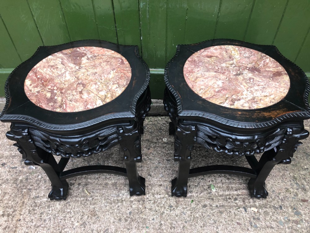 Pair of ebonised wooden side tables featuring pierced floral carvings and circular pink marble inset tops. View II